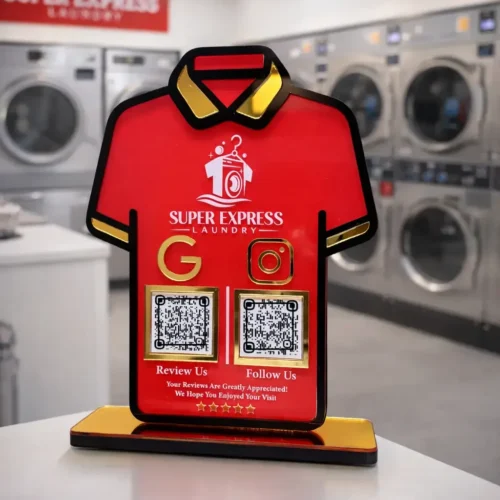 T-shirt shaped laundry NFC standee with Google review and social media QR codes on red acrylic display with gold base